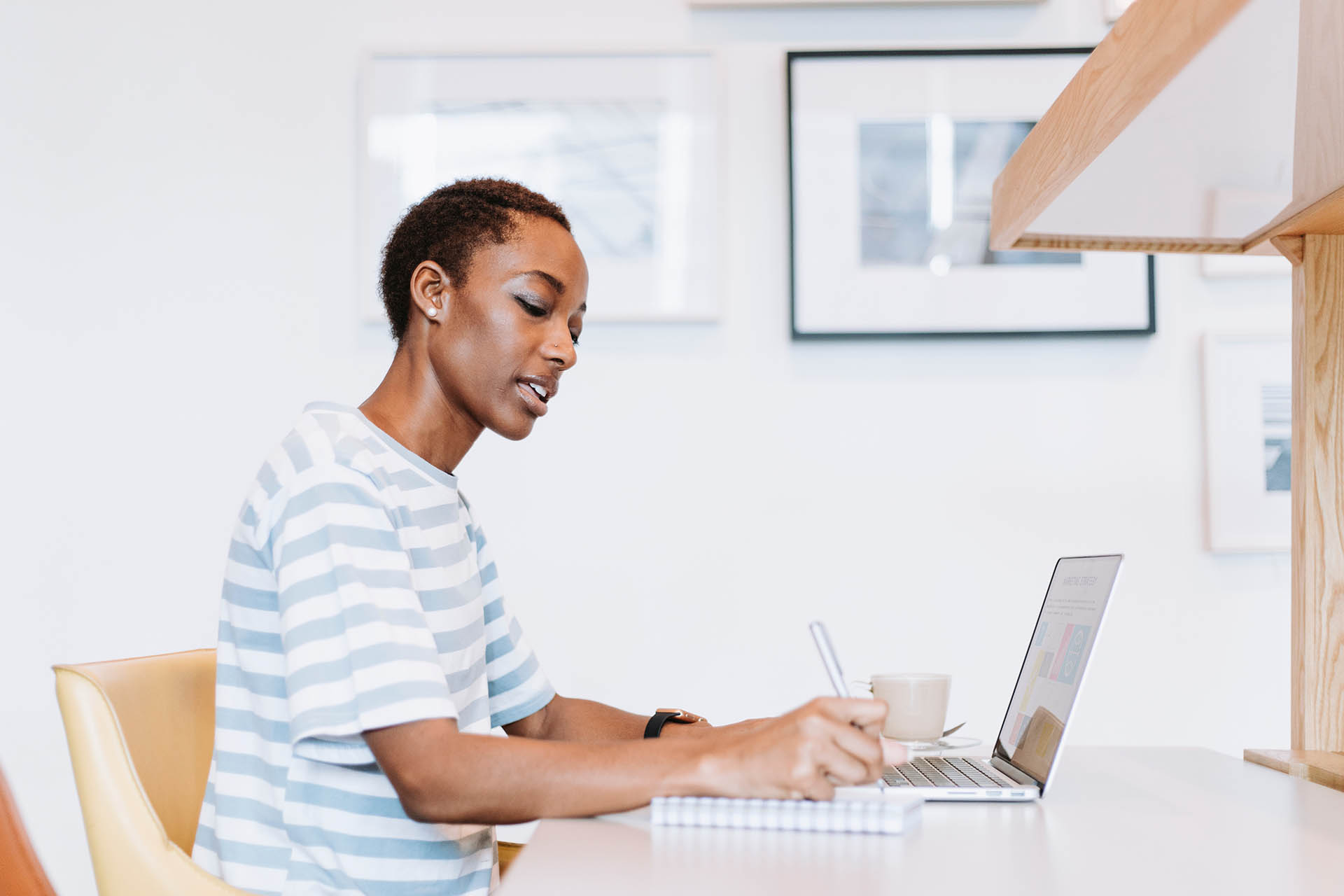 A woman sits in a chair looking at her computer