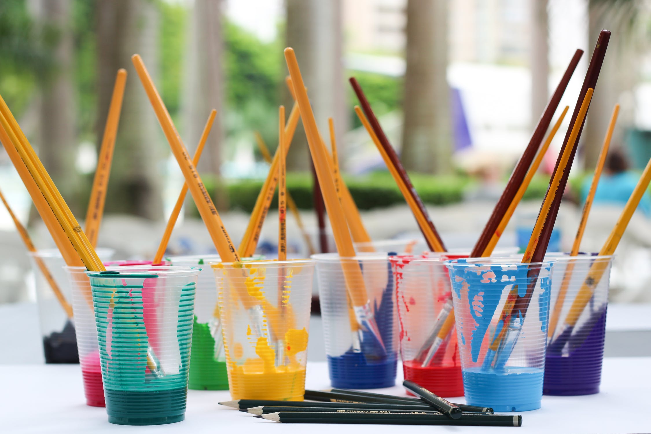 Paintbrushes in cups with paint